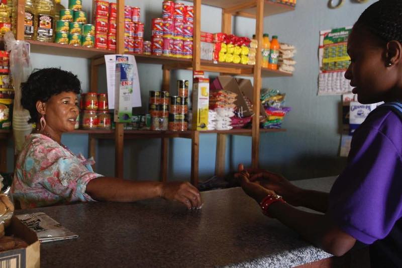 A spaza shop owner sells to a customer: picture by SIMON MATHEBULA